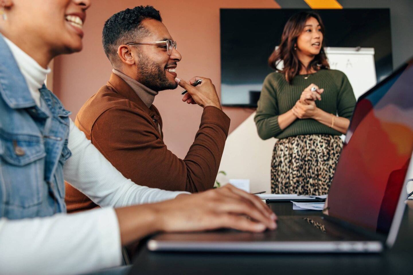 Group of diverse businesspeople having a meeting in a boardroom. Young businesspeople smiling happily during a discussion. Multiethnic businesspeople working together as a team.