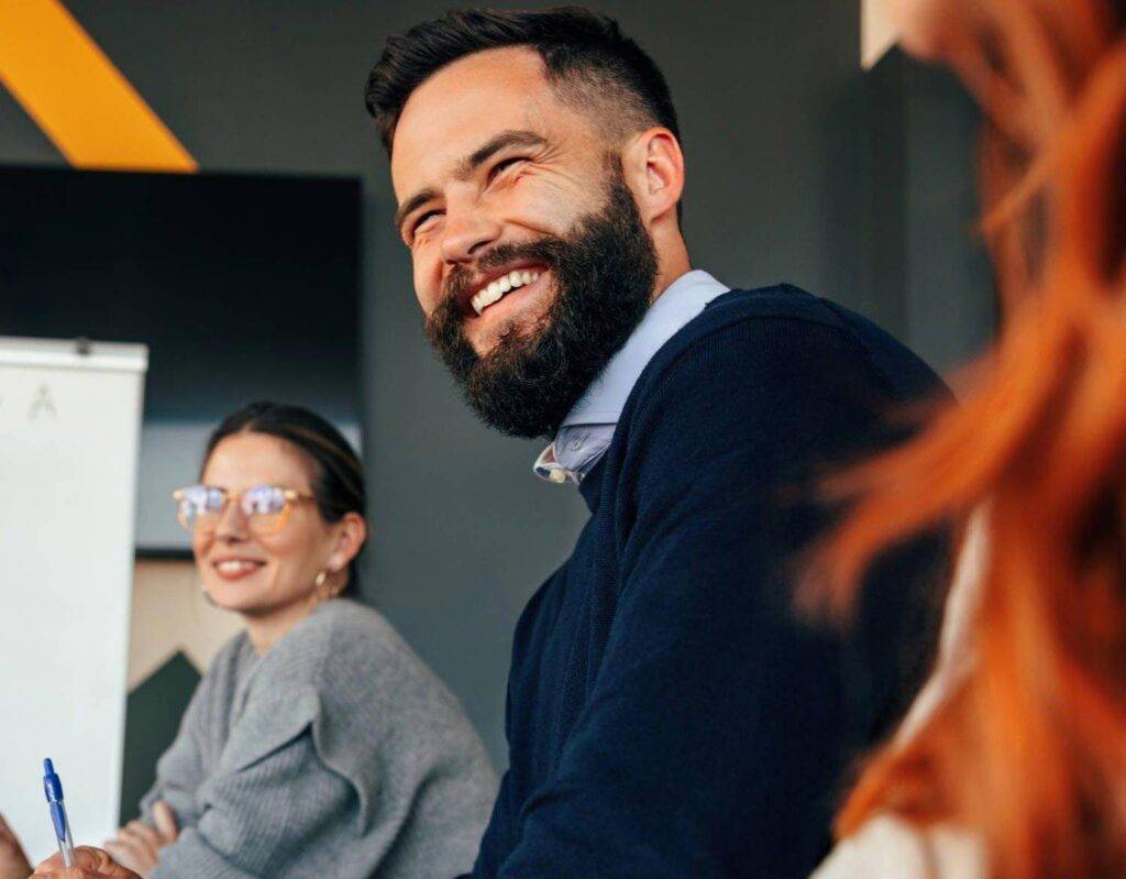 Happy businesspeople smiling during a boardroom meeting. Group of diverse businesspeople attending a presentation in a modern office. Young entrepreneurs working together as a team.